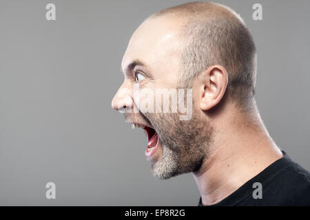 Ritratto di angry man urlando isolato su grigio Foto Stock