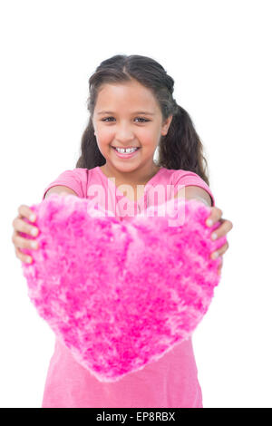 Sorridente bambina che mostra il cuscino a forma di cuore Foto Stock