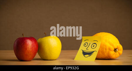 Limone con post-it nota sorridente in apple Foto Stock