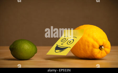 Limone con post-it nota sorridente a lime Foto Stock