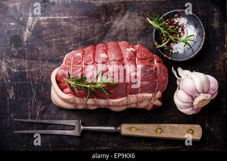 Materie arrosto di manzo, condimenti a base di carne e sulla forcella di metallo scuro dello sfondo Foto Stock