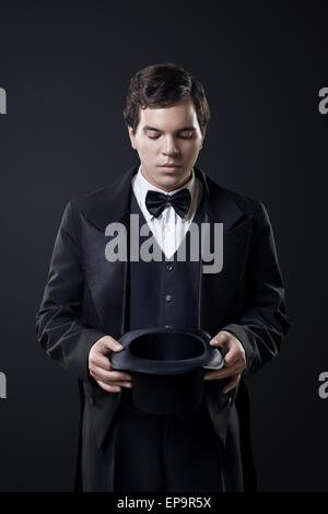 Il mago che mostra i trucchi con top hat isolato Foto Stock