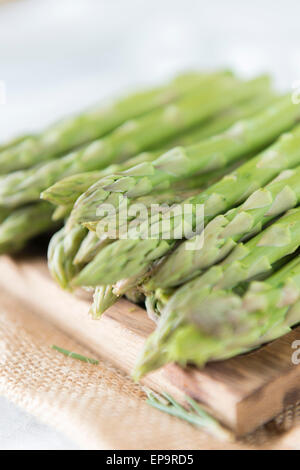 Gli asparagi spears su un tagliere. Foto Stock