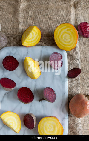 Rosso di barbabietola e golden barbabietola sul marmo di un tagliere. Foto Stock