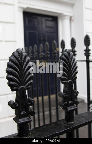 Nero ringhiere in ferro di fronte blu porta anteriore, London House Foto Stock