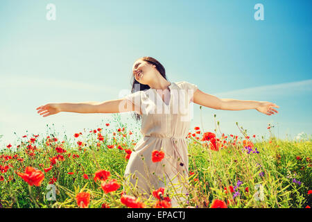 Sorridente giovane donna sul campo di papavero Foto Stock