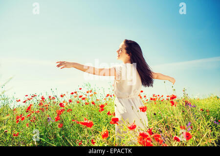 Sorridente giovane donna sul campo di papavero Foto Stock