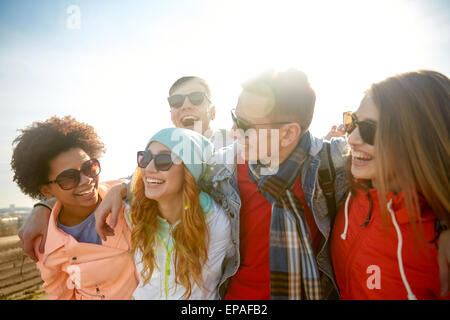 Sorridente amici in occhiali da sole di ridere su strada Foto Stock