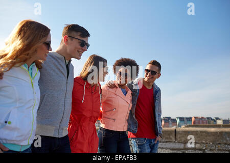 Happy amici adolescenti a piedi lungo una strada di città Foto Stock