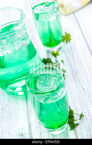 Vini spumanti Woodruff bere in un bicchiere (sul luminoso sullo sfondo di legno) Foto Stock