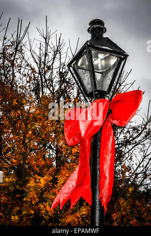 Rossa gigante archetti sono legate intorno alla lampada posti all'entrata di Jackson Square nel Quartiere Francese di New Orleans, LA, Foto Stock