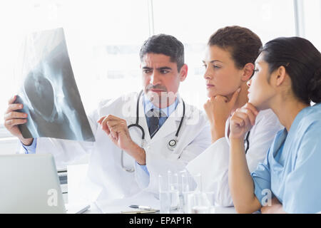 Medico maschio discutendo xray con i colleghi Foto Stock