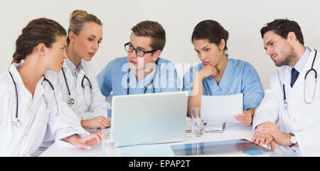 Il team medico di discutere su laptop Foto Stock