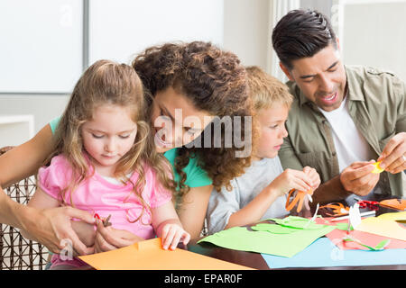 Allegro famiglia facendo arti e mestieri assieme al tavolo Foto Stock