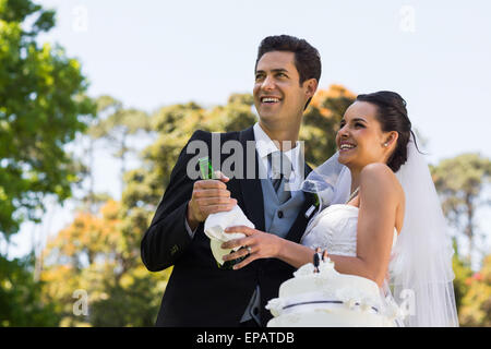 Sposa giovane con bottiglia di champagne presso il park Foto Stock