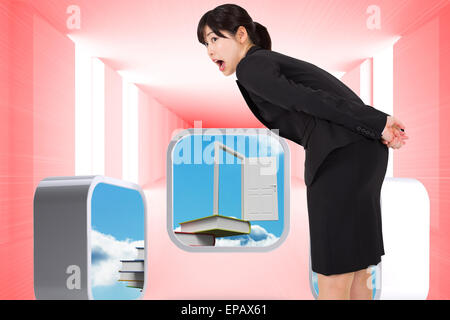 Immagine composita di sorpreso imprenditrice la piegatura Foto Stock