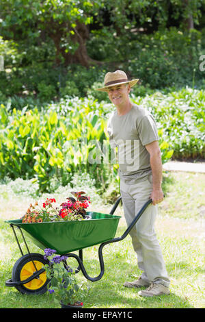 Mappy giardinaggio maschio con carriola in giardino Foto Stock