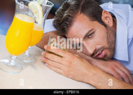 Imprenditore ubriaco crollati sulla barra accanto al cocktail Foto Stock