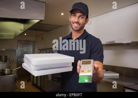 Allegro pizza consegna uomo tenendo la macchina per le carte di credito Foto Stock