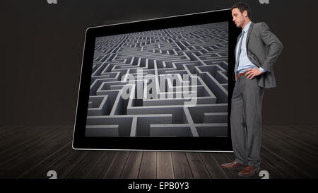 Immagine composita di grave imprenditore con le mani sui fianchi Foto Stock