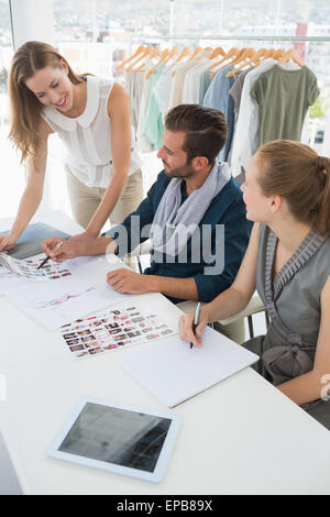 Tre disegnatori di moda a discutere di progetti Foto Stock
