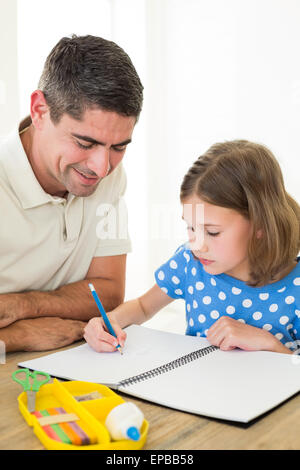 Ragazza disegno mentre padre seduto da Foto Stock