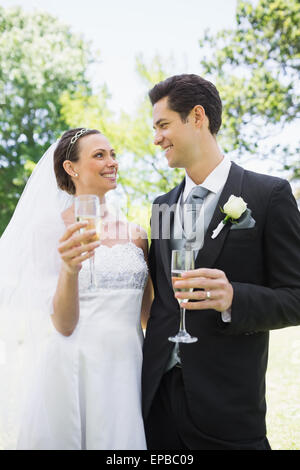 Romantico sposa e lo sposo con champagne in posizione di parcheggio Foto Stock
