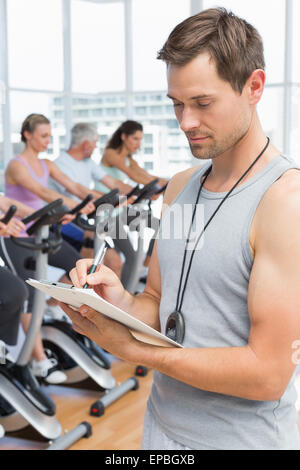 Trainer con persone che lavorano alla classe di filatura Foto Stock