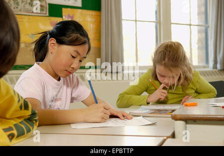 Grado 3 studenti di sesso femminile lavora al loro scrivanie Foto Stock