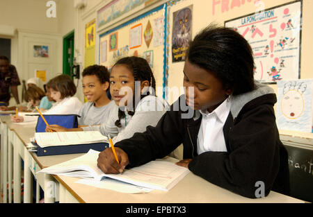 Grado 5 studenti che lavorano alle loro scrivanie in aula Foto Stock