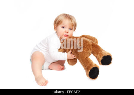 Little Boy cuddling con il suo orsacchiotto di peluche Foto Stock