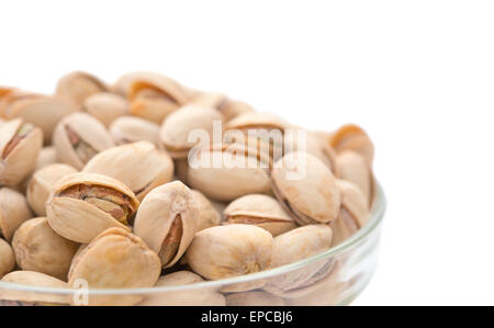 I pistacchi in una ciotola di vetro da vicino con il tracciato di ritaglio Foto Stock