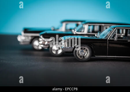 Vintage toy cars standing lateralmente su sfondo blu Foto Stock