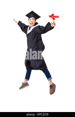 Felice studente laureato in accappatoio jumping isolato su bianco Foto Stock