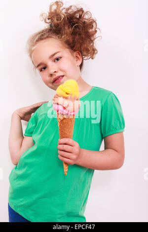 Bionda e giovane ragazza ondulata con cono gelato in mano Foto Stock