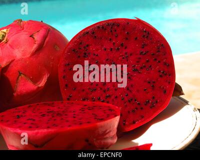 Tutta la Pitaya accanto a un Pitaya tagliati a metà Foto Stock