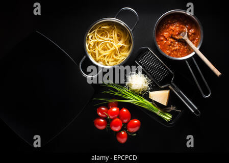 Fresche spaghetti con sugo di pomodoro e formaggio parmigiano su sfondo nero Foto Stock