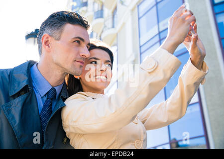 Coppia felice rendendo selfie foto all'aperto Foto Stock