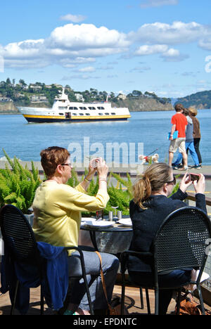 I turisti scattare foto con i cellulari a Sausalito Cafe Foto Stock