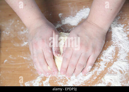 Donna massaggia la pasta sul tavolo Foto Stock