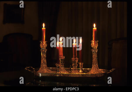 Candele accese nel buio di una sala da pranzo Foto Stock