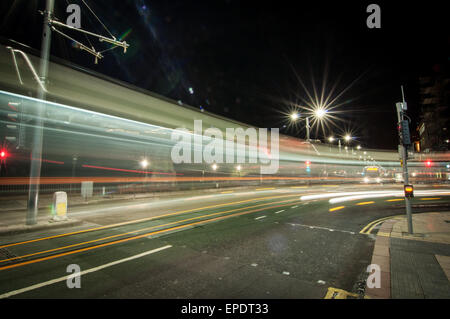 I percorsi della luce a sinistra da un bus ruotando di un angolo su Princes Street di Edimburgo, Scozia Foto Stock