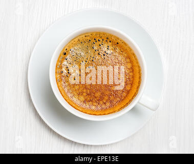 Caffè lungo in una tazza bianca su un tavolo, primo piano Foto Stock