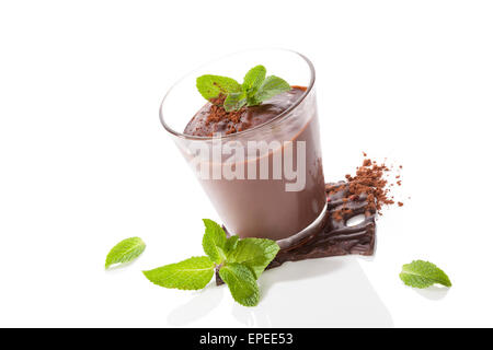 Budino di cioccolato con foglie di menta fresca e barra di cioccolato isolato su sfondo bianco. Delizie dessert. Foto Stock