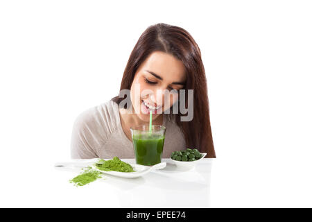 Bella ragazza sorridente bere drink di verde. Spirulina, clorella e wheatgrass. Uno stile di vita sano, detox. Foto Stock