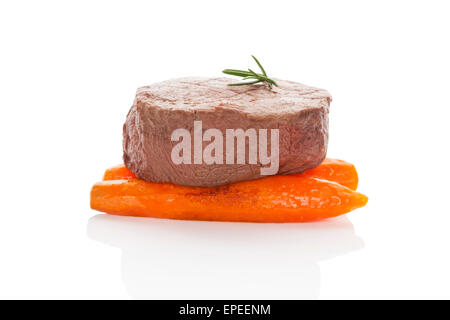 Il filet mignon. Lussuoso bistecca di filetto su carote cotte al vapore isolato su sfondo bianco. Delizie a base di carne rossa mangiare. Bbq bistecca Foto Stock