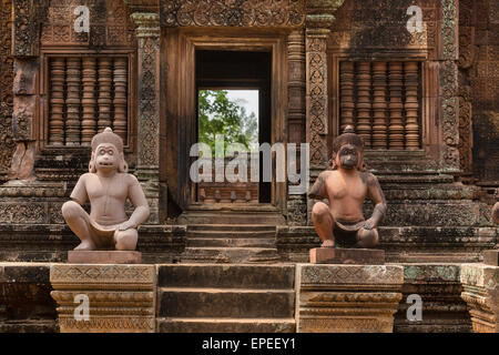 Yaksha custode, ape-come custode figure nella parte anteriore del Mandapa, Khmer tempio indù Banteay Srei, regione di Angkor Foto Stock