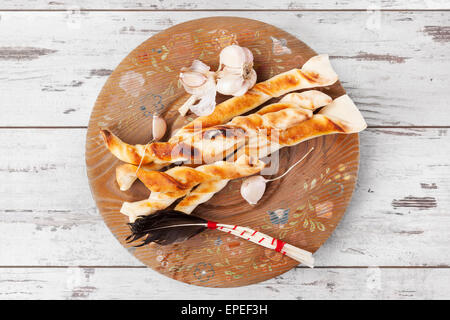 Pizza deliziosa bastoni sul piatto di legno bianco su sfondo di legno. Pizza di lusso sfondo, vintage stile rustico. Foto Stock