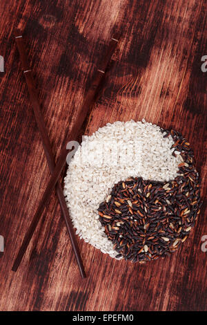 Bianco e vietato il riso con bacchette in legno scuro dello sfondo. Vista dall'alto. Mangiare sano concetto. Foto Stock