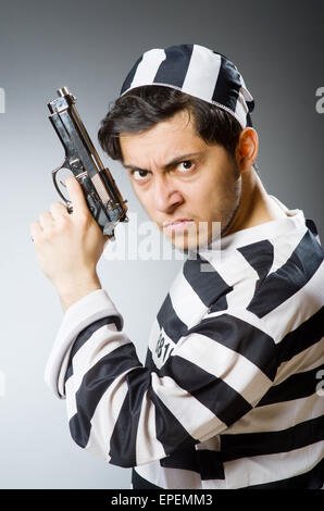 Prigioniero con la pistola contro uno sfondo scuro Foto Stock